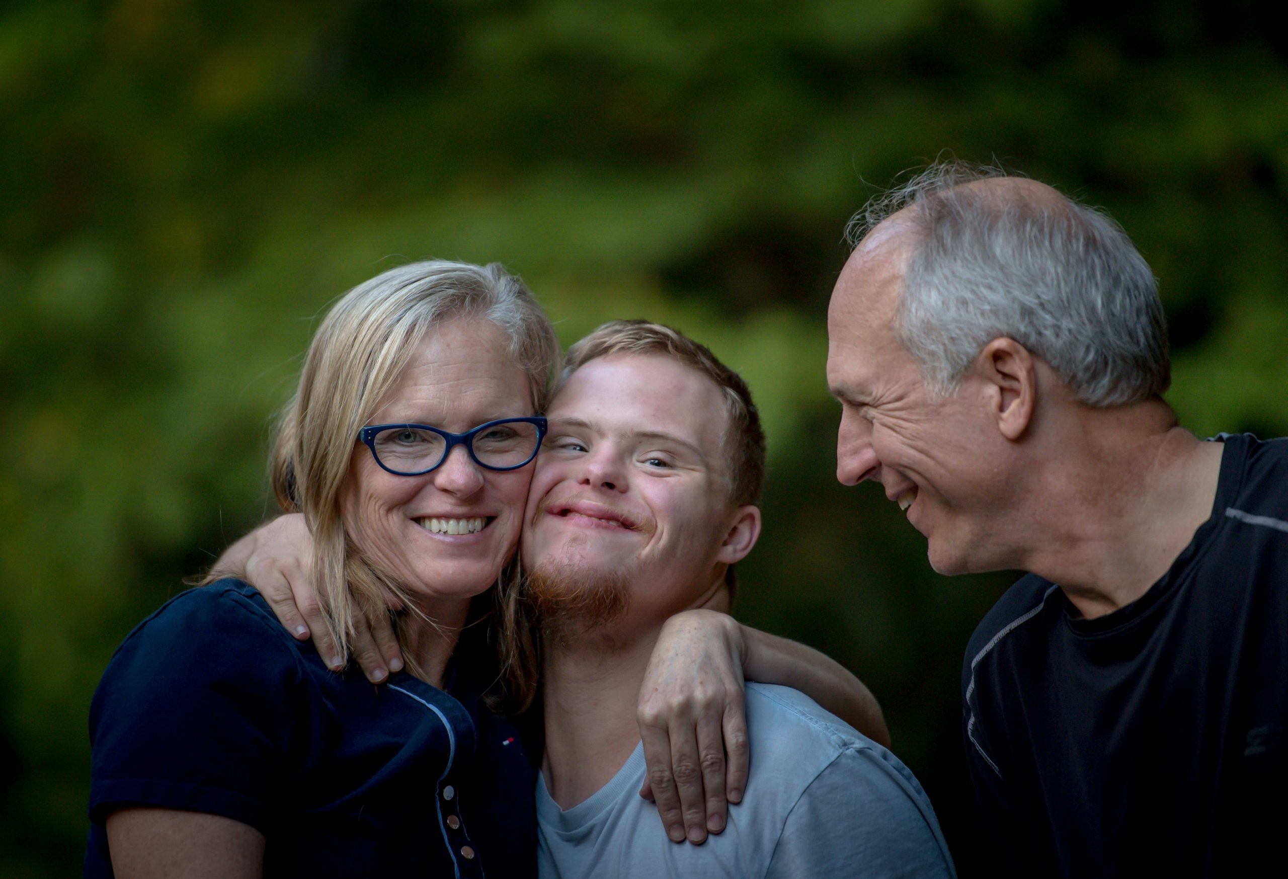 Padres o familiares junto a un joven con discapacidad sonriendo